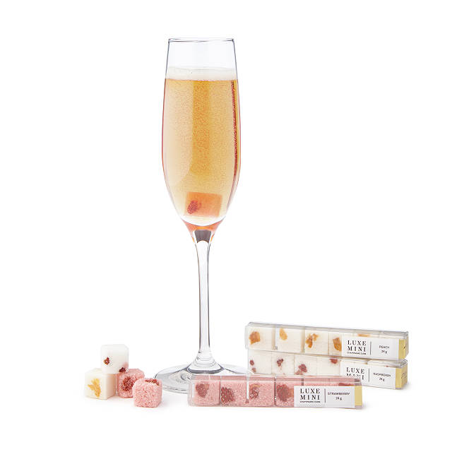 Glass of champagne surrounded by flavored sugar cubes