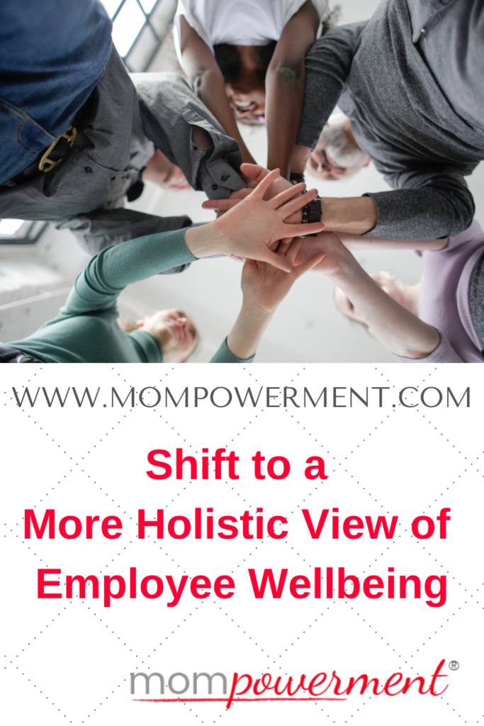 View of a group of people with hands touching in the center taken from the ground looking up Shift to a More Holistic View of Employee Wellbeing Mompowerment